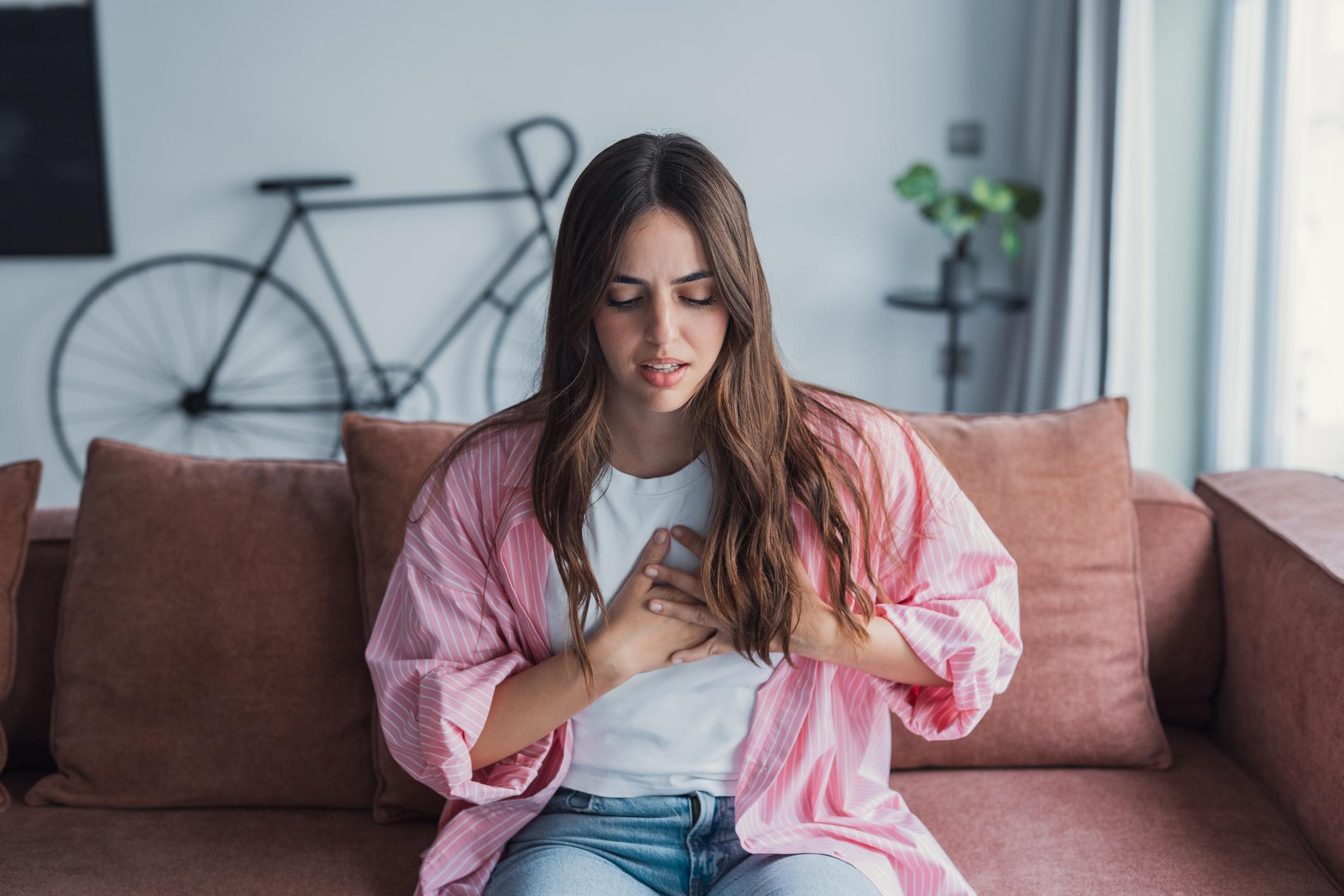 Person experiencing anxiety chest pain and rapid heartbeat symptoms