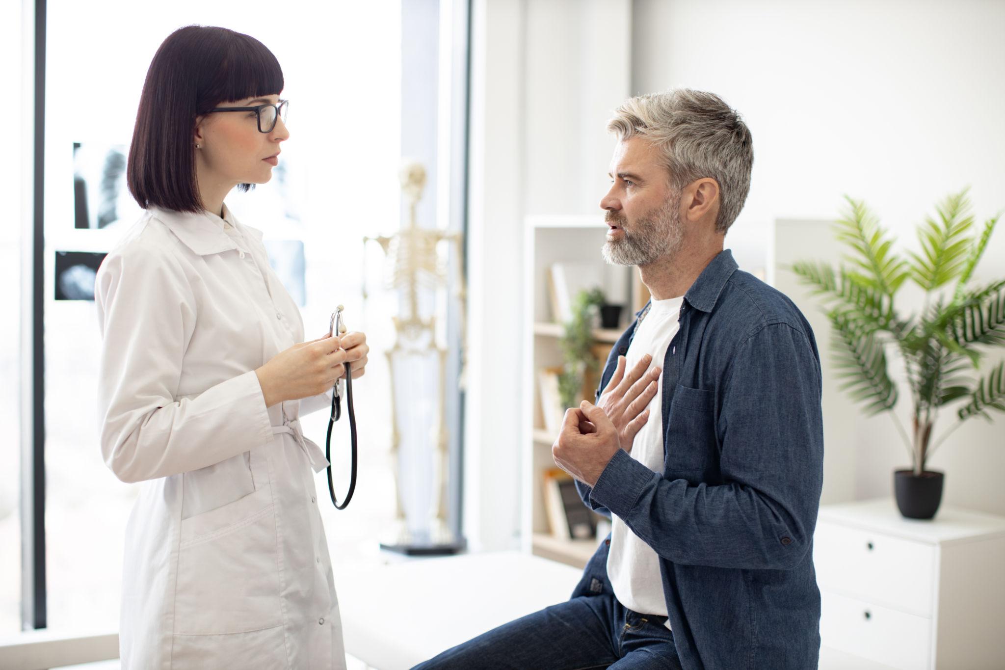 Doctor cardiologist evaluating patient with chest pain symptoms consultation