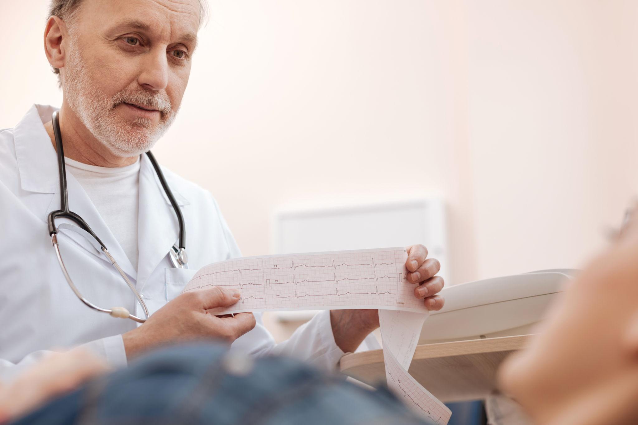 Doctor cardiologist examining patient for heart symptoms and chest pain evaluation